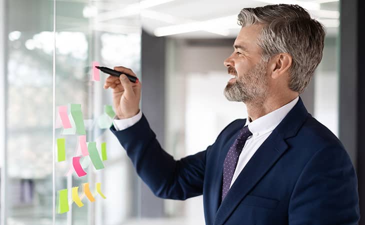 man-writing-postit
